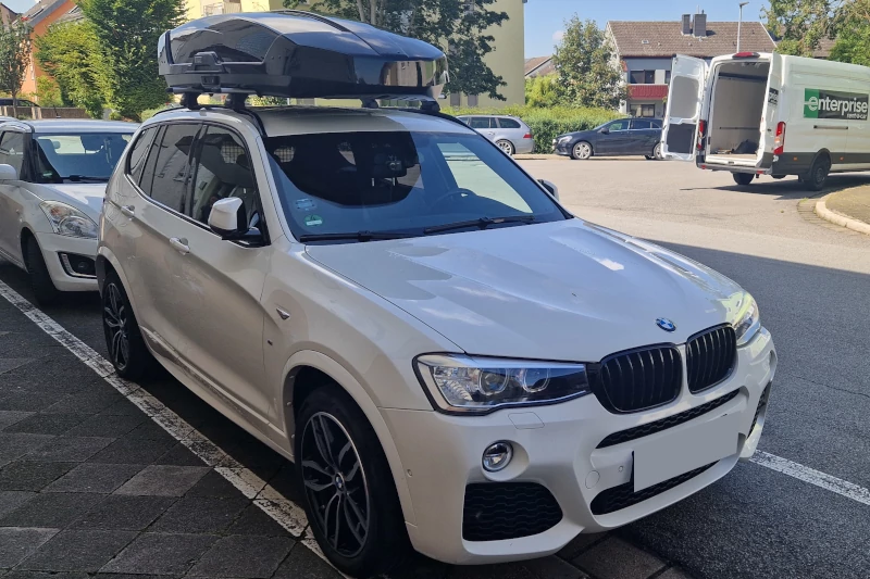Ein BMW X3 mit einer Dachbox mit 610 Liter Volumen