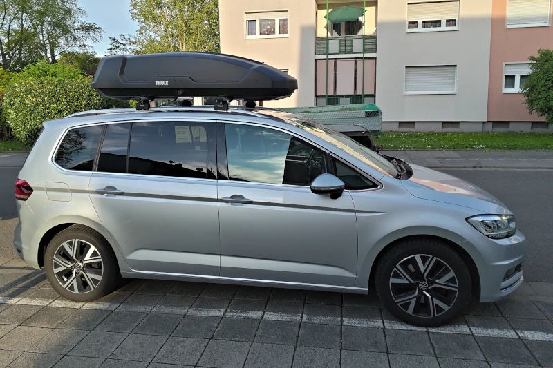Ein VW Touran mit einer Dachbox von Thule mit 450 Liter Volumen