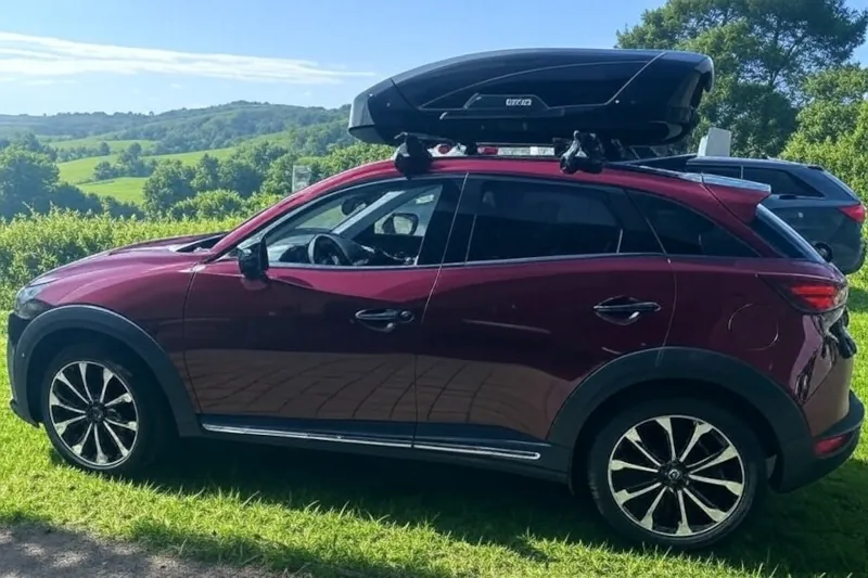 Ein Mazda CX-3 mit einer Dachbox von THULE mit 400 Liter Volumen