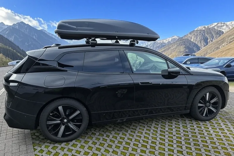 Ein BMW iX mit einer Dachbox mit 600 Liter Volumen