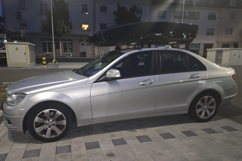 Ein Mercedes C-Klasse Stufenheck mit einer THULE-Dachbox mit 610 Liter Volumen in Breitenthal