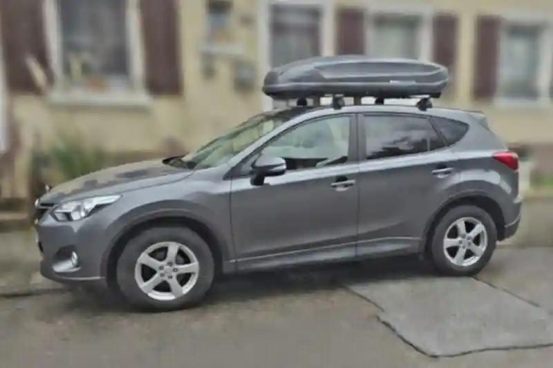 Eine Dachbox von NORAUTO mit THULE-Wingbar-Alu-Dachträgern auf einem Mazda CX-5
