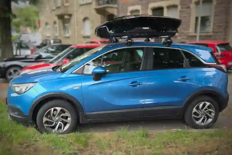 Eine Motion-Dachbox von THULE mit Wingbar-Alu-Dachträgern auf einem Opel Crossland in Mannheim