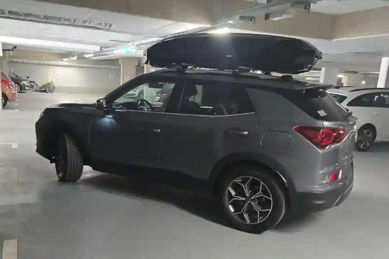 Eine Dachbox von THULE mit Wingbar-Alu-Dachträgern auf einem KGM Korando