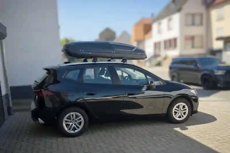 Eine Dachbox von Norauto mit Wingbar-Dachträgern auf einem BMW Active Tourer