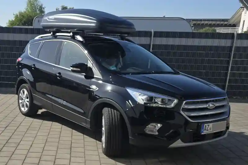 Eine Dachbox von NORAUTO mit Wingbar-Dachträgern von THULE auf einem Ford Kuga