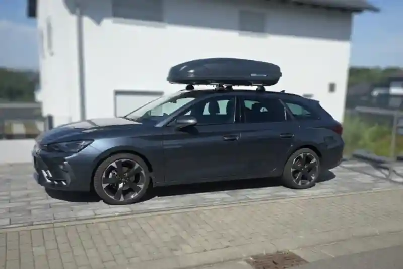 Eine Dachbox von NORAUTO mit 385 Liter Volumen und Wingbar-Dachträgern von THULE auf einem Cupra Leon Sportstourer Kombi