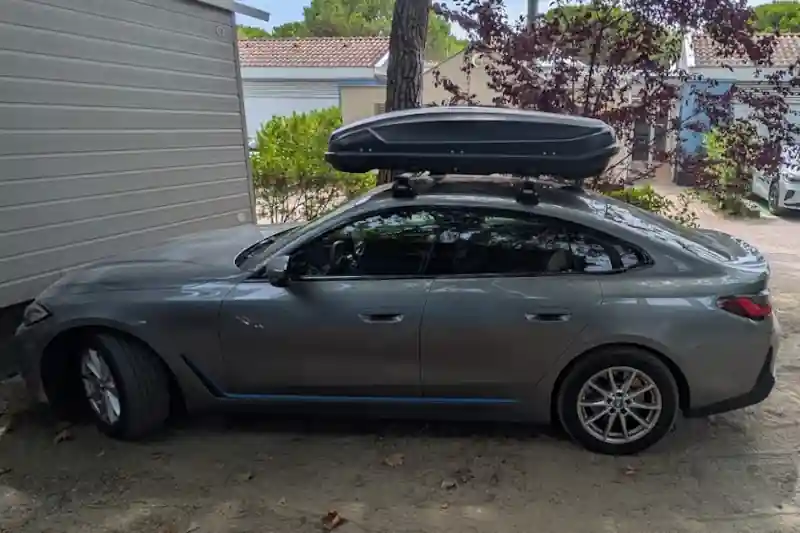 Eine Dachbox von NORAUTO mit Wingbar-Dachträgern auf einem BMW i4