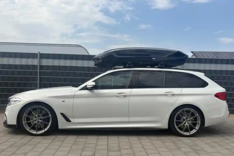 Eine Dachbox von THULE mit Wingbar-Dachträgern auf einem BMW 5er Touring Kombi