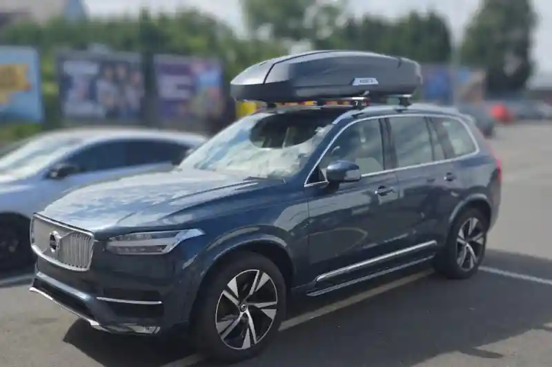 Eine Dachbox von Hapro mit Wingbar-Dachträgern von Thule auf einem Volvo XC90 SUV