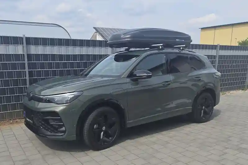 Eine Dachbox von Norauto mit Wingbar-Dachträgern von Thule auf einem VW Tiguan Variant Kombi