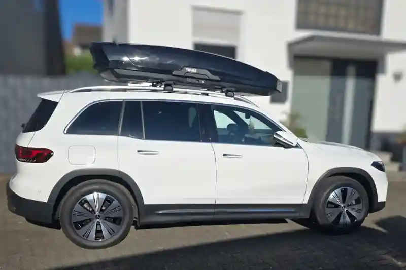 Eine Dachbox Modell Motion XXL von Thule mit Wingbar-Dachträgern auf einem Mercedes EQB SUV