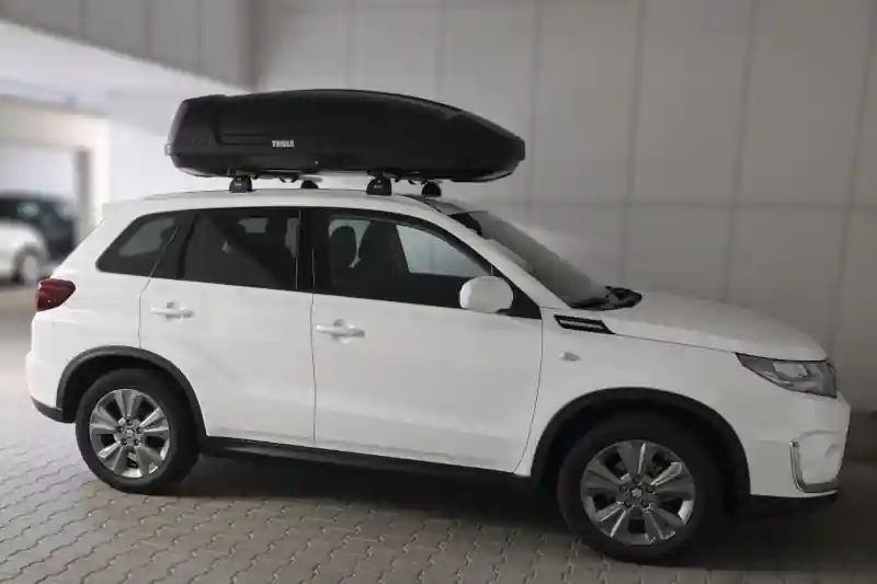 Eine Dachbox Modell Force von Thule mit Wingbar-Dachträgern auf einem Suzuki Vitara SUV