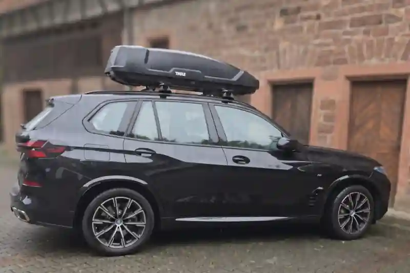 Eine Dachbox Modell Force von Thule mit Wingbar-Dachträgern auf einem BMW X5