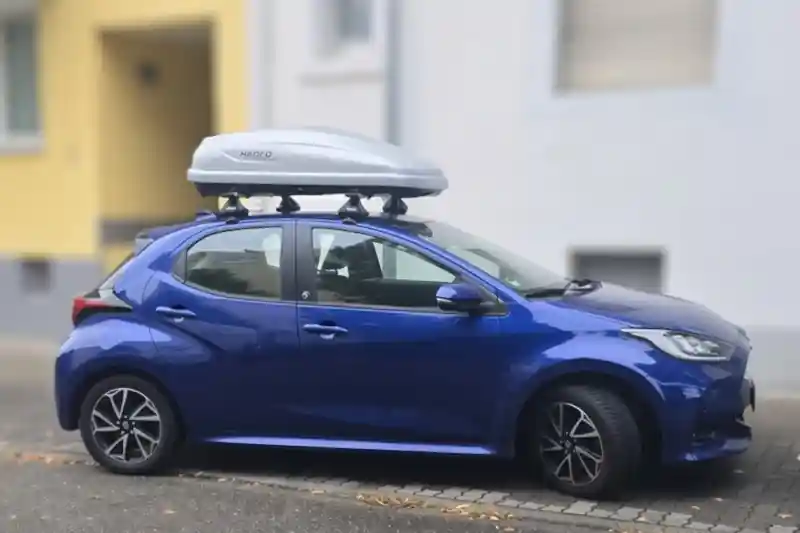 Eine Dachbox Modell Force von Thule mit Wingbar-Dachträgern auf einem Toyota Yaris