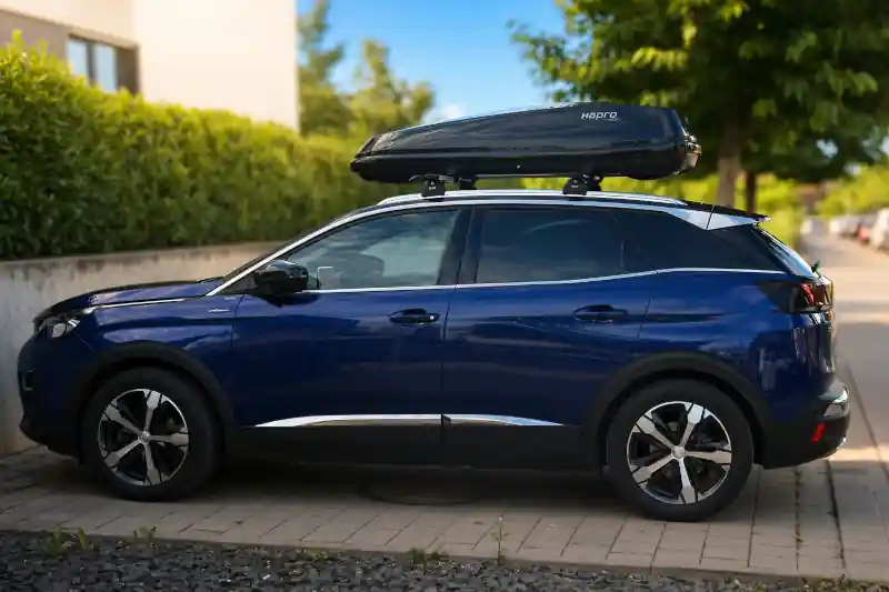 Eine Dachbox von HAPRO mit 430 Liter Volumen mit Wingbar-Dachträgern von THULE auf einem Peugeot 3008