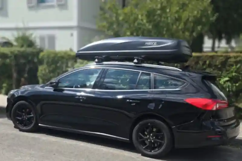 Eine Dachbox von HAPRO "Cruiser" mit 600 Liter Volumen mit THULE-Wingbar-Dachträgern auf einem Ford Focus Kombi