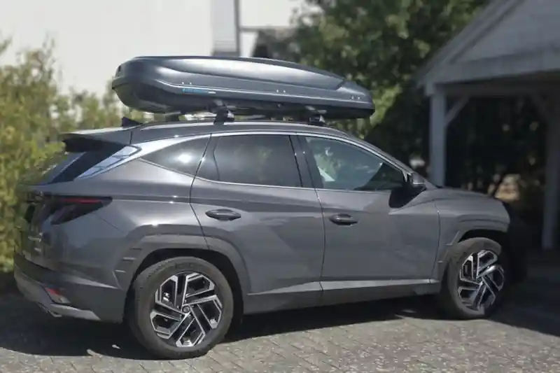 Ein Hyundai Tucson mit einer Dachbox von NORAUTO mit 530 Liter Volumen
