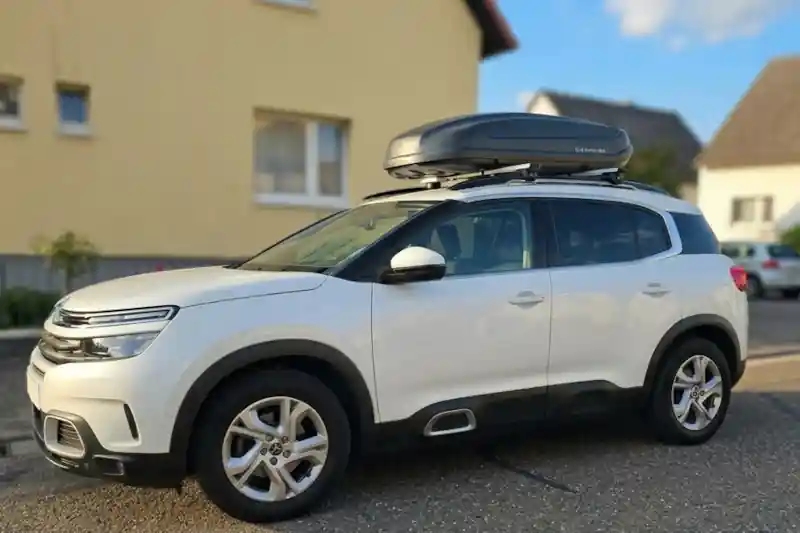 Eine Dachbox mit THULE-Grundträgern Wingbar auf einem Citroen C5 Aircross