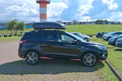Eine Norauto-Dachbox mit 385 Liter Volumen und Wingbar-Dachträgern auf einem Ford Kuga