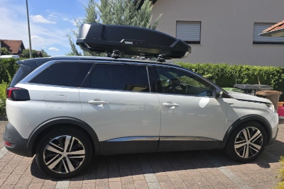 Eine THULE Dachbox "Force XT" mit 450 Liter Volumen mit Wingbar-Dachträgern auf einem Peugeot 5008