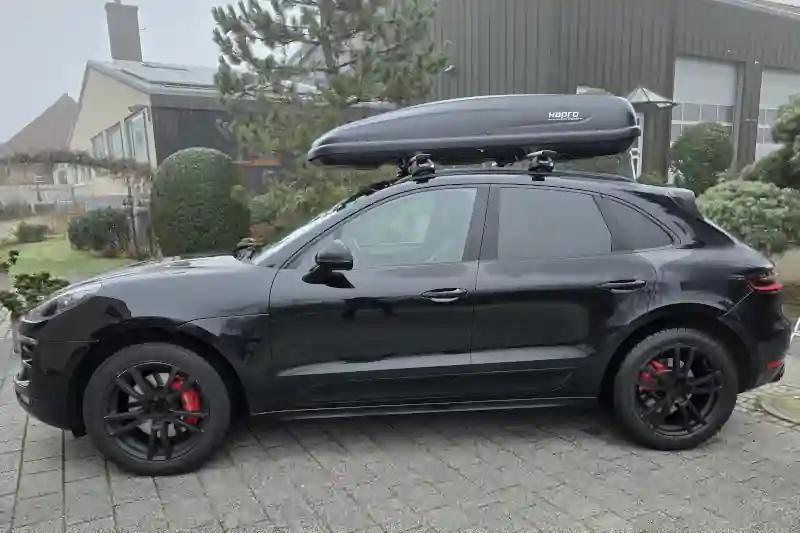 Eine Dachbox mit 530 Liter Volumen mit Wingbar-Dachträgern von Thule auf einem Porsche Macan
